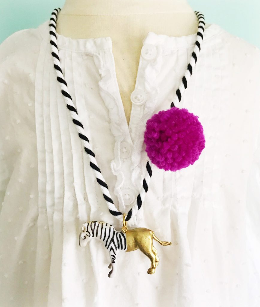 A 9 year old girl picks her favorite clothes for 9 year olds, like this pom pom and zebra charm necklace
