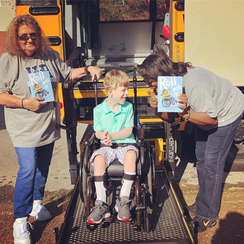 Roll with It by Jamie Sumner: Jamie's son Charlie giving copies of the book to his bus drivers from @jamiesumner_author on Instagram