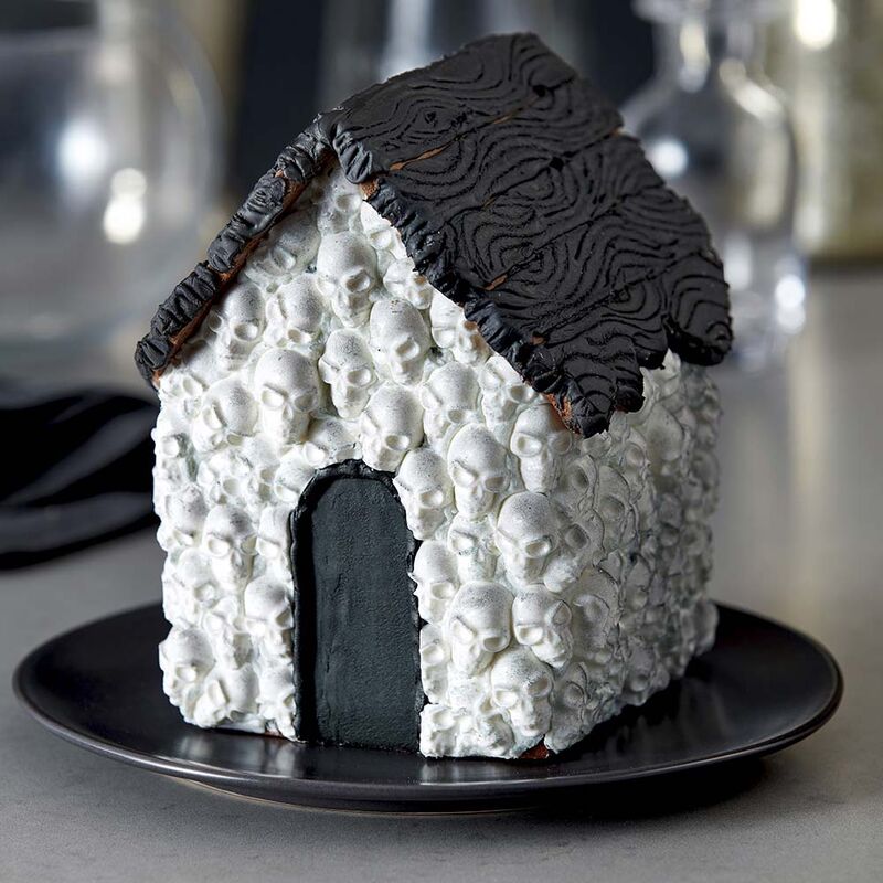 How to DIY a haunted gingerbread house: Cover it with candy skulls in this tutorial at Wilton