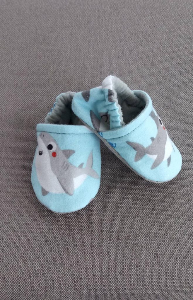 https://coolmompicks.com/wp-content/uploads/2021/01/baby-gifts-under-10-shark-crib-shoes-659x1024.jpg