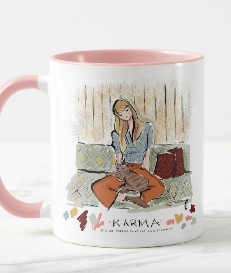 Taylor Swift gifts for fans: The Taylor Swift Karma is a Cat mug illustrated by Jennifer Vallez